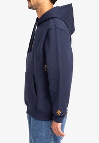 Felpa con cappuccio blu navy in misto cotone, dotata di tasca frontale, polsini a costine e dettagli ricamati sulla manica.