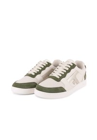 Sneaker con una toma crema e accenti in suede verde, pannelli in rete testurizzati e lacci crema su una suola bianca in gomma.