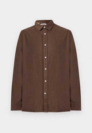 Ruda ilgomis rankovėmis marškiniai su mygtukų apykakle, turintys tekstūruotą audinį ir baltus mygtukus priekyje.