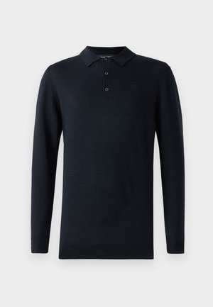 Tamnoplavi polo majica dugih rukava s ovratnikom, tri gumba i mekanom teksturom. Ima suptilan logo na prsima.