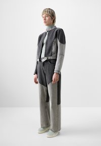 Chaqueta de denim y pantalones a juego en tonos grises, con paneles en contraste y un diseño corto. Los accesorios incluyen una blusa verde menta y zapatillas.