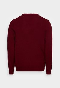 Pull en maille bordeaux avec une texture lisse, col rond, manches longues et poignets et ourlet côtelés. Design simple sans motifs ni accents.