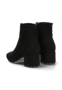 Botas de tobillo de ante negro con punta afilada y tacón cuadrado. Presentan una textura suave y un cierre de cremallera en la parte posterior para facilitar su colocación.