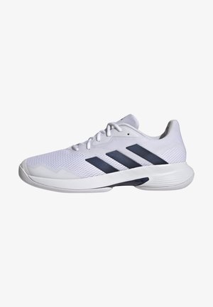 Shoe atlético branco com parte superior em malha respirável, design de três riscas em azul marinho, sola texturizada e biqueira arredondada para maior estabilidade.