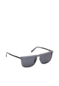 Lunettes de soleil grises élégantes avec verres rectangulaires foncés et branches noires fines, reposant sur une surface blanche.