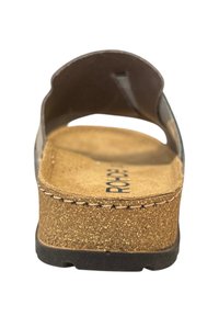 Bruine kurken sleehak sandaal met een platte zool, open achterkant en twee gebogen banden boven de voet. Getextureerde binnenzool en zichtbare stikseldetails.