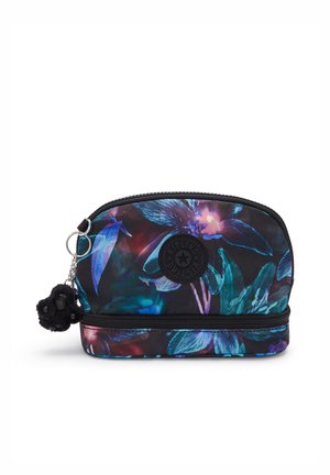 Una borsa nera con motivo floreale, dotata di zip e un logo rotondo. Ha una forma rettangolare e una texture liscia, con un charm a pom-pom nero attaccato.