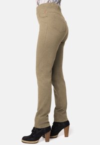 Pantalones de tiro alto en verde oliva, confeccionados con una tela suave y elástica, que cuentan con bolsillos traseros y un diseño de piernas rectas y ajustadas.