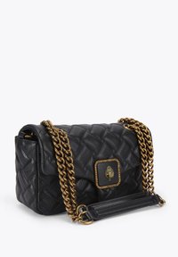 Czarna pikowana skórzana torebka z paskiem łańcuchowym w złotym odcieniu i złotymi elementami. Posiada kwadratowe zapięcie z dekoracyjnym emblematem oraz dwa sposoby noszenia.
