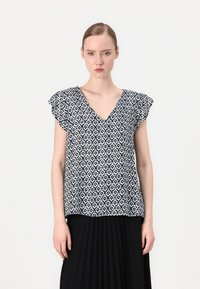 Marinblus med vitt mönster, V-ringning och korta volangärmar, med en geometrisk design, avslappnad passform och mjuk textur.