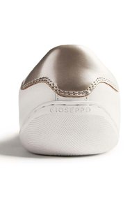 Sneaker bianco con un elegante accento metallico dorato sul tallone, suola testurizzata e marchio Gioseppo sul retro. Design pulito e minimalista.