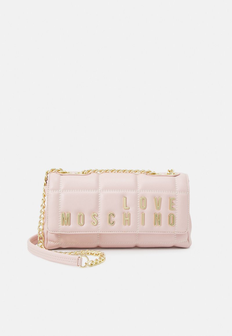 Borsa a tracolla trapuntata rosa con catena dorata. Presenta la scritta "LOVE MOSCHINO" in lettere metalliche sul davanti. Texture liscia e forma strutturata.