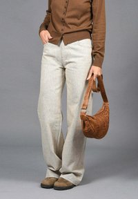 Pantalones de pierna ancha beige hechos de tejido texturizado, combinados con un cárdigan marrón y un bolso de hombro de cuero marrón. Botines de ante marrón.
