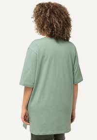 T-shirt oversize verde menta realizzata in morbido cotone, con maniche corte, scollatura rotonda e fessure laterali per facilitare il movimento.