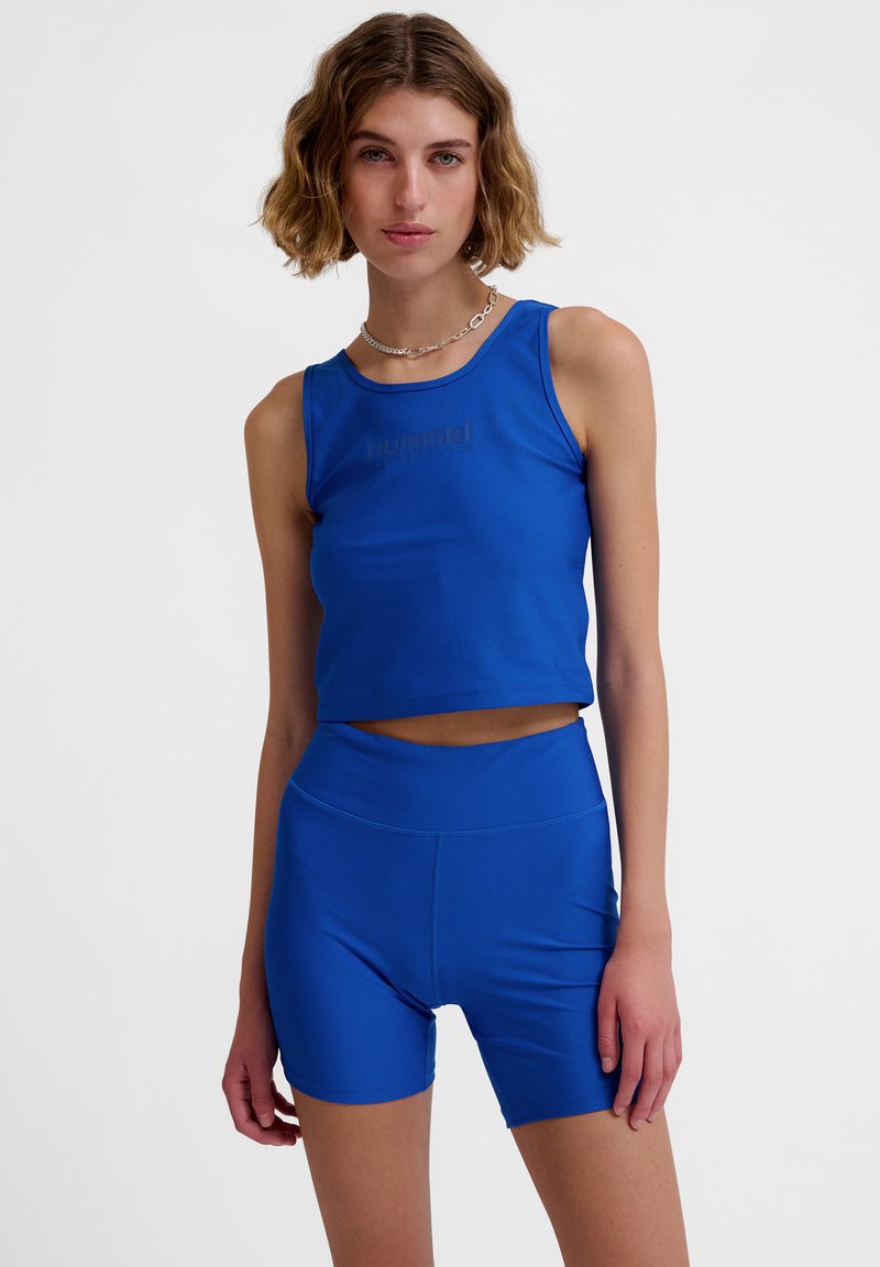 Blue athletic cropped tank top with a logo in the center, paired with high-waisted blue shorts, both made from smooth, stretchy material.