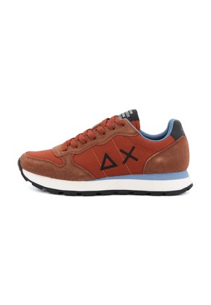 Brązowy i rdzawej kolorystyce sneaker z zamszowymi akcentami, czarne geometryczne logo po boku, niebieska podszewka wewnętrzna i biała podeszwa z czarnym bieżnikiem.