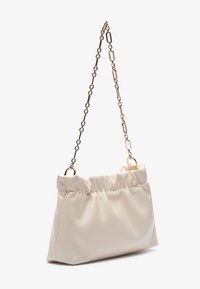 Borsa di colore crema, con una texture morbida e un design arricciato, dotata di una tracolla in catena dorata. Presenta elementi hardware ovali e una base strutturata.