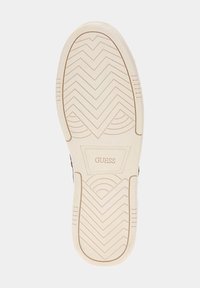 Semelle de basket blanche avec motifs de bande de roulement en zigzag, comportant un logo hexagonal GUESS de couleur claire au centre.