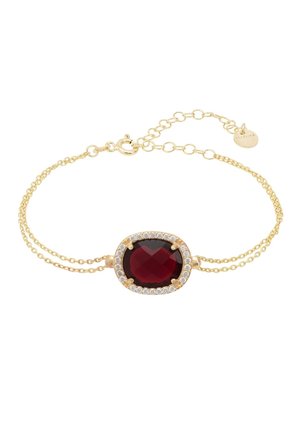 Gold bracelet featuring an oval, faceted red stone surrounded by a circle of small clear stones; dual delicate chain design with a clasp.