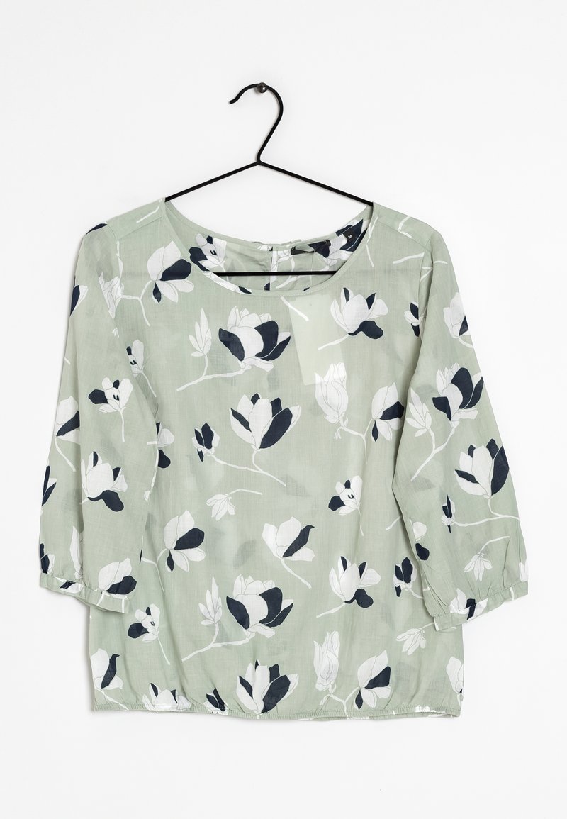 Blusa verde chiaro con stampa floreale in bianco e nero, caratterizzata da maniche a tre quarti, scollatura rotonda e vestibilità ampia.