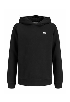 Dreng står iført en sort hættetrøje med teksten "JJR", lyseblå brede jeans og hvide sneakers mod en ensfarvet lys baggrund.