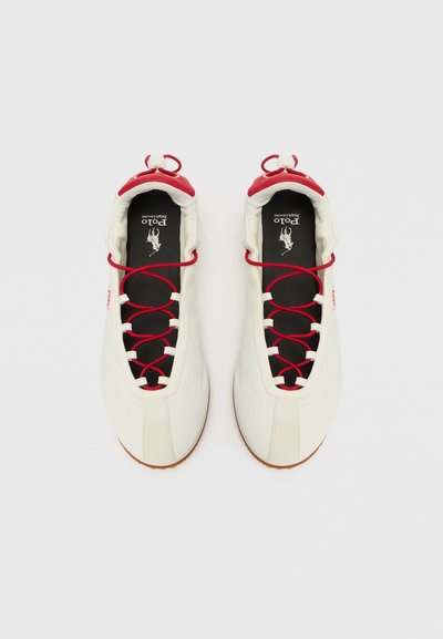 Hvite sportssko med røde detaljer, med en unik snøring, teksturert overdel og svarte innleggssåler. Lysebrune gummisåler.