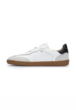 Zapatillas de cuero blancas con detalles en gamuza gris, talón negro, suela de goma marrón y cordones blancos. Presentan un diseño minimalista y costuras sencillas.