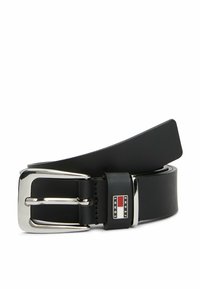 Cinturón de cuero negro con un diseño ancho, que cuenta con una hebilla rectangular de plata brillante. Se ha añadido un parche con el logo cerca de la hebilla.