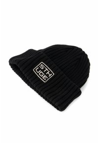 Berretto di lana nero lavorato a maglia con risvolto, texture a coste e una patch rettangolare con il testo "STHUGE" in bianco.