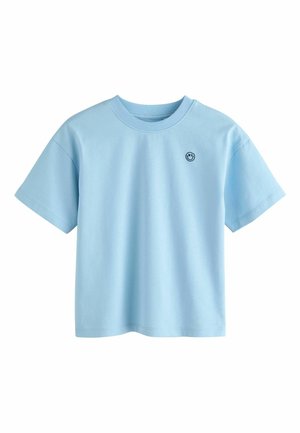 Vaaleansininen puuvillapaita, jossa on pyöreä kaula-aukko, lyhyet hihat ja pieni musta logo vasemmassa rinnassa. Yksinkertainen ja rento muotoilu.