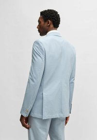 Ljusblå strukturerad kavaj med en enda slits, med en slim fit och knäppta manschetter. Slät tyg med ett subtilt mönster.