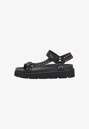 Sorte sandaler med nitter, justerbare stropper og en kraftig såledesign. Fremstillet af syntetiske materialer med en glat tekstur.