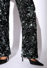Črne sequins hlače širokega kroja, z bleščečo, teksturirano površino, okrašene s sijočimi, srebrnimi sequins.