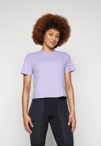 Tricou scurt cu mânecă, croppat, de culoare lavandă, fabricat dintr-un material ușor. Prezintă un decolteu rotund și detalii subtile ale cusăturii.