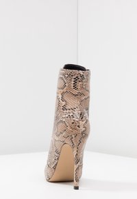 Känga med faux ormskinsmönster i ljusbrun och beige, med spetsig tå och hög stilettklack, samt en slät ovansida och solid sula.