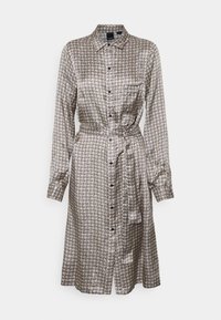 Button-up shirt dress made of patterned fabric in beige and black. Features long sleeves and a tie belt at the waist.