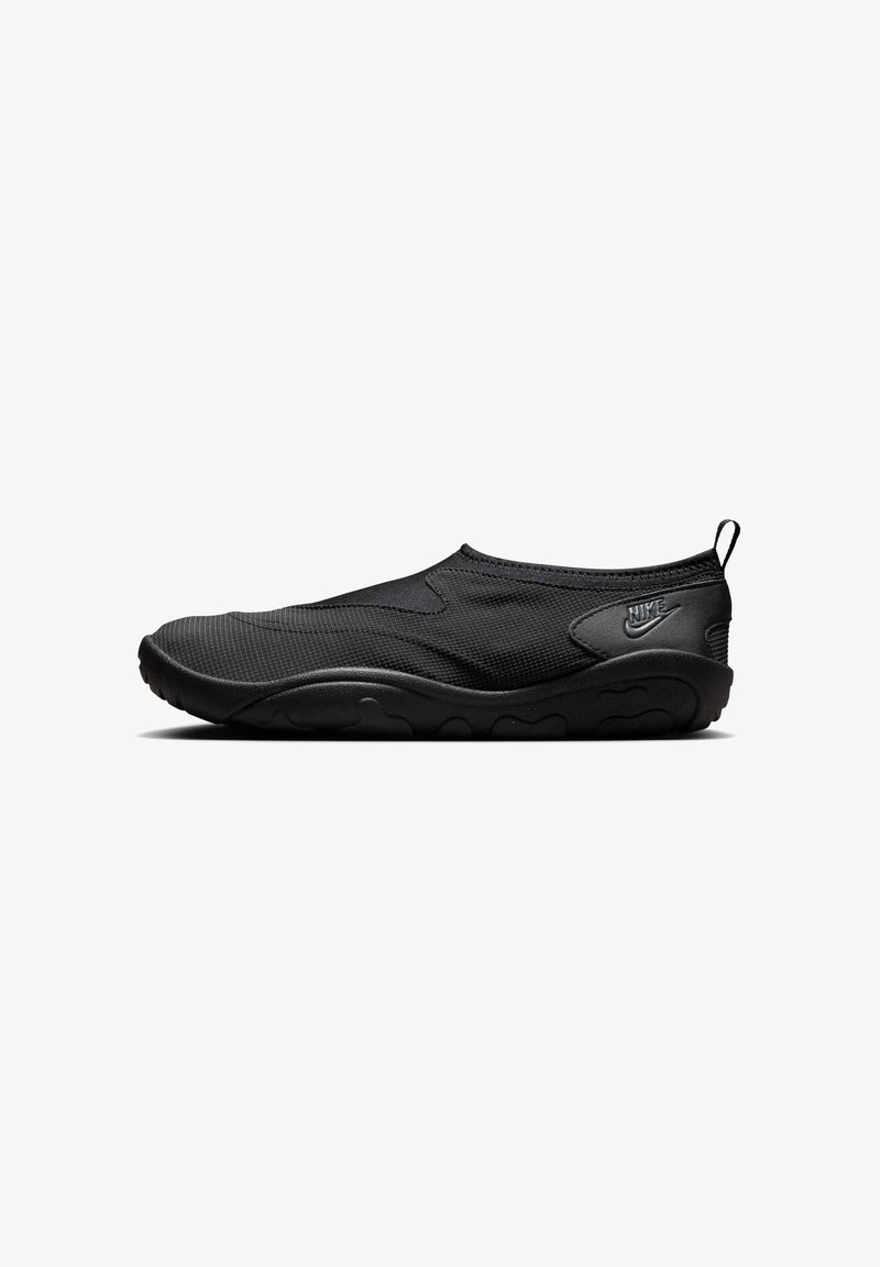 Heltsort Nike slip-on-sko med teksturert stoffoverdel, gummisåle og draslepp ved hælen, vist i profil fra høyre side.