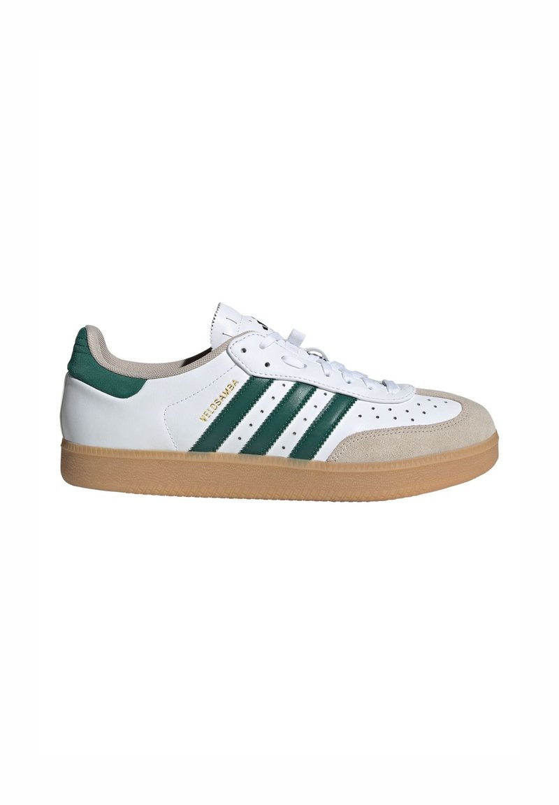Weißes Sneakers mit grünen Streifen, Wildleder-Akzenten und einer Sohle aus Gummi. Mit perforierter Zehenpartie und flachen weißen Schnürsenkeln. Markennamen sichtbar.