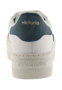 Vit sneaker med teal mocka hälaccent, texturerad gummisula och präglad "victoria"-logotyp på baksidan. Slät syntetisk ovandel.