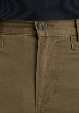 Spodnie khaki z gładkiego, teksturowanego materiału. Wyposażone w metalowy guzik i zamek błyskawiczny, z widocznym przeszyciem i kieszeniami bocznymi.