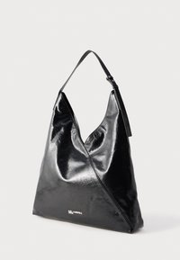 Czarna błyszcząca skórzana trójkątna torebka z regulowanym paskiem na ramię i małym srebrnym logo "Karl Lagerfeld Jeans" na przodzie.