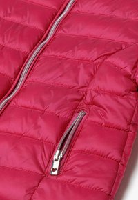 Rosa puffjacka med horisontell quiltad sömnad, fram silverfärgad dragkedja och en ficka med dragkedja som har en hjärtformad dragkrok.