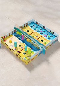 Colorful board game featuring a blue and yellow design with various animal characters and holes for pegs in pink and green.