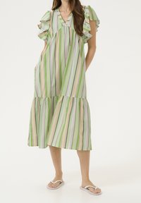 Zielona, paskowana sukienka maxi z falbanami na rękawach i dekoltem w kształcie litery V. Materiał jest lekki, a spódnica warstwowa z luźnym fasonem.