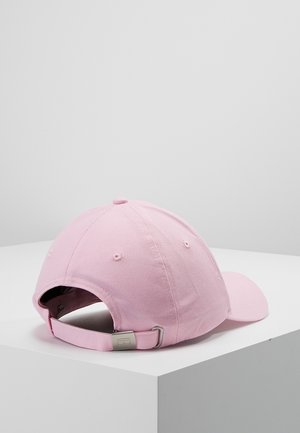 Lyserød baseballkasket, der hviler på en hvid overflade, set bagfra, der viser justerbar rem med metalspænde.