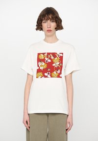T-shirt in cotone bianco con una grafica rossa caratterizzata da motivi floreali e la parola "MAX" in lettere dorate. Maniche corte e vestibilità rilassata.
