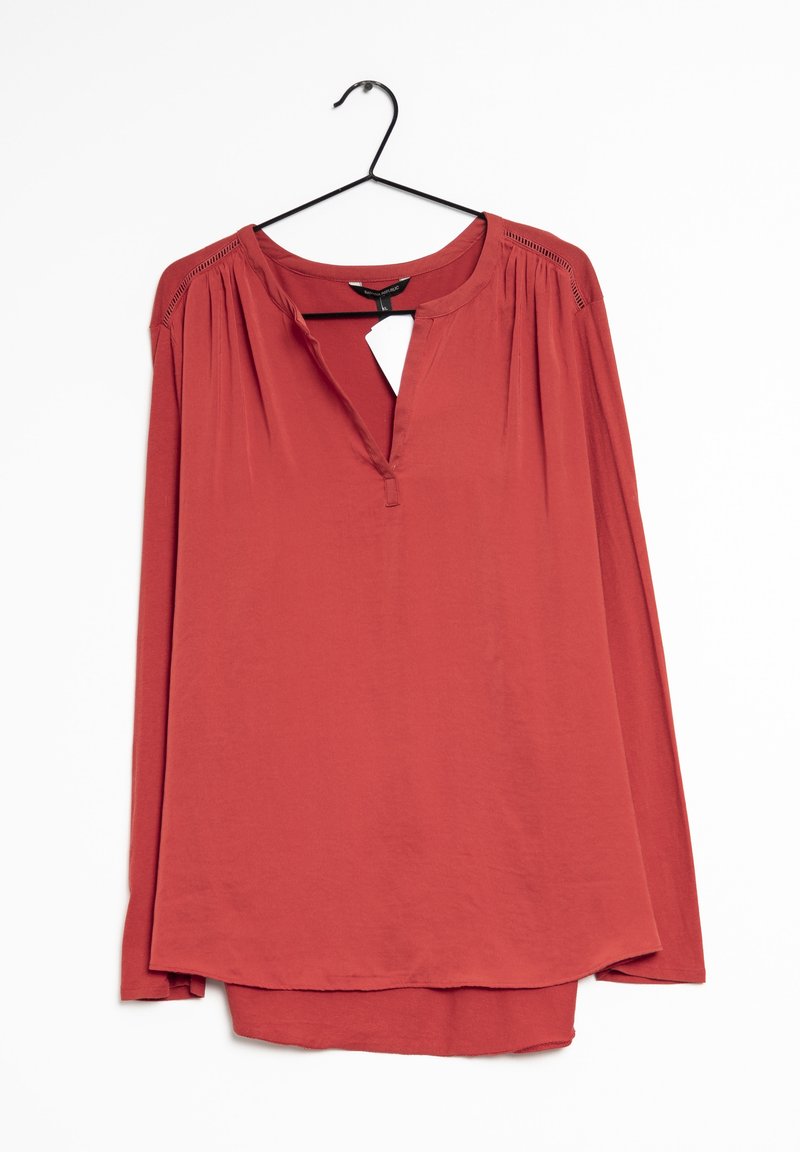 Blouse à manches longues couleur rouille avec un col en V et un détail œillet. Tissu doux, épaules plissées et coupe décontractée. Étiquette suspendue visible.