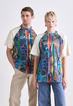 Farverige mønstrede t-shirts med korte ærmer, der har blå, grønne, røde og gule striber. T-shirtsene har en kridhvid krave.