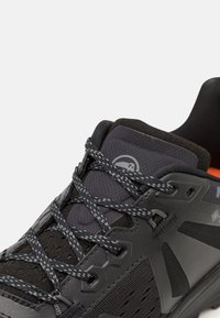 Scarpe sportive nere con tomaia testurizzata, pannelli in rete e lacci grigi. Caratterizzate da un collare imbottito e un logo sulla linguetta.