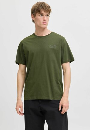 Camiseta de algodón verde oliva con mangas cortas y cuello redondo. Presenta un logo impreso sutil en el área del pecho izquierdo. Textura suave.